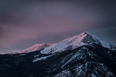 白雪皑皑的山峰在黑色的阴天
